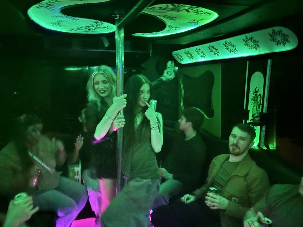 Guests dancing at the pole under green LED lights