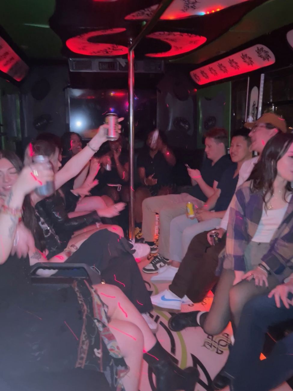 A full bus of guests celebrating under red lights